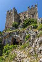 AI generated majestic castle built on a rocky hill, surrounded by lush greenery Ai generated photo