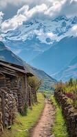 ai generado tranquilo campo escena estrecho suciedad camino líder pasado antiguo Roca y madera estructuras, con el majestuoso nieve tapado montañas en el fondo debajo parcialmente nublado cielo. ai generado foto