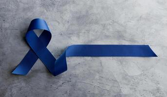 Prostate Cancer Awareness Campaign Concept. Men Healthcare. Close up of a Blue Ribbon  Lying on Rough Grey Cement Concrete background, Top View photo