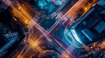 AI generated image is an aerial view of busy city intersection at night. Multiple roads converge at this point, creating an intricate pattern marked by various lanes and crosswalks. Ai Generated photo