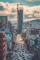 AI generated Photo of cityscape with street filled with moving cars. Buildings of different heights and designs flank both sides of the street. Ai Generated