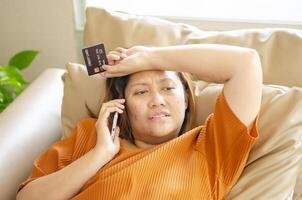woman talks on the phone with a call center operator and after tricked into transferring money by a scammer. photo