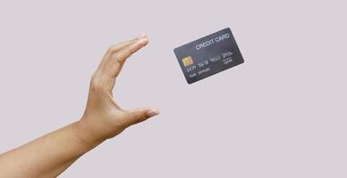 Woman hand and black credit card mockup floating, used for online shopping and online transactions. isolated on grey background photo