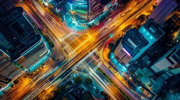 AI generated image is an aerial view of busy city intersection at night. Multiple roads converge at this point, creating an intricate pattern marked by various lanes and crosswalks. Ai Generated photo