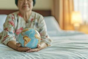 AI generated Elderly Asian patient with globe symbolizes health in hospital. photo