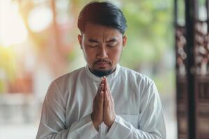 ai generado religioso asiático musulmán hombre Orando foto