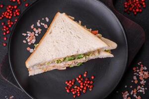Delicious nutritious sandwich with toast bread, ham, tomatoes, cheese and sauce photo