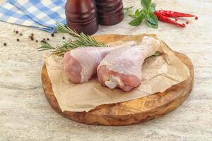 Raw chicken leg over board photo