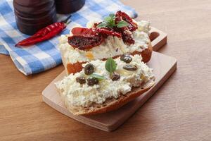 bruschetta with soft cheese capers and tomato photo