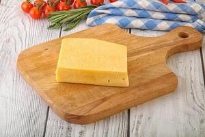 Piece of natural organic cheese over board photo