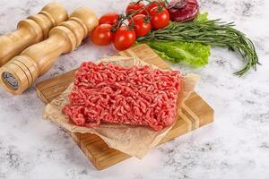 Raw minced beef meat on cutting board photo