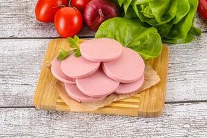 Slices boiled sausages for breakfast photo