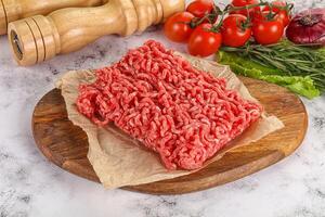 Raw minced beef meat on cutting board photo