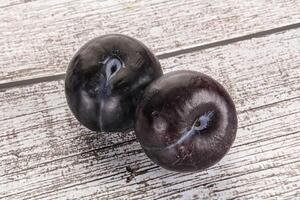 Two ripe sweet black plums photo