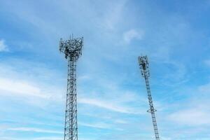 Internet signal tower or mobile phone signal tower isolated on blue sky background texture. Global communication and internet network connection concept photo