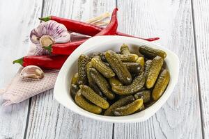 Marinated small cucumbers in the bowl photo