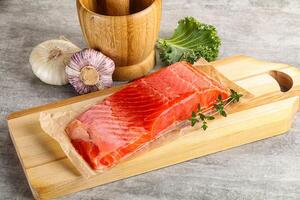 Raw salmon fillet over board photo