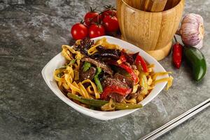 Asian wok with noodle, vegetables and beef photo