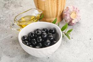 Black olives with oil and branch photo