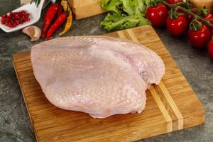 Raw chicken breast with skin photo