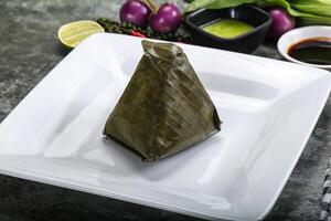 Asian cuisine - rice with filling in banana leaf photo