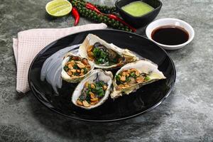 Open half oysters with green onion photo