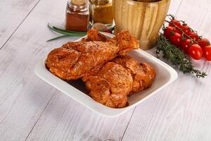 Raw turkey shoulder wing in Indian tandoori marinade photo