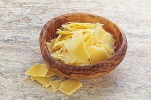 Sliced parmesan cheese heap in the bowl photo