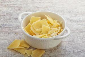 Sliced parmesan cheese heap in the bowl photo