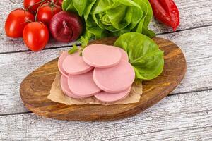 Slices boiled sausages for breakfast photo