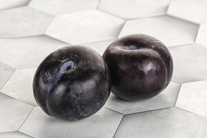 Two ripe sweet black plums photo