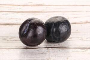 Two ripe sweet black plums photo