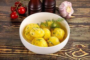 Boiled potato with oil and dill photo