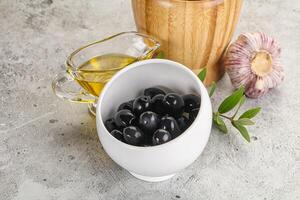 Black olives with oil and branch photo