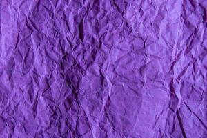 Crumpled purple paper texture background. Wrinkled paper surface for designs. photo