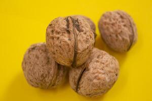 Top view of dried walnuts on yellow background with copy space photo