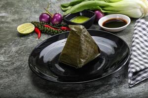 Asian cuisine - rice with filling in banana leaf photo