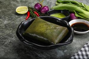 Asian cuisine - rice with filling in banana leaf photo