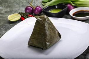 Asian cuisine - rice with filling in banana leaf photo