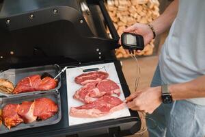 Preparation for Cooking meat on an open grill with temperature check photo