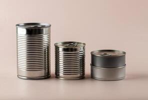 Various Size Canned Food on Pink Background photo