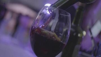 Refreshing sangria, punch with fruits and red wine poured into the glass in slow motion. Frame. Glass with citrus fruits is being filled with red wine. video