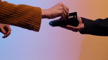 Payment with magnetic stripe credit card through the terminal, isolated on blue and yellow background. Stock. Close up for woman paying by chipless card through credit card machine. video