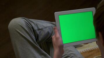 Rear view of blurred man holding a tablet with a blank editable green screen. Man holding tablet with green screen - back view video