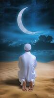 AI generated Rear view of a Muslim man sitting while raised hands and praying in the land with crescent moon at night photo