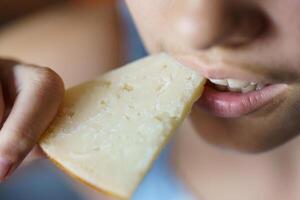 Closeup of crop teenage girl eating fresh cheese at home photo