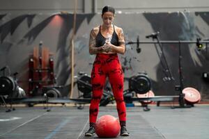 Woman ready to use a medicinal ball in a gym photo