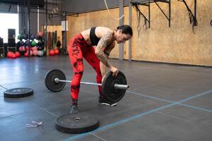 Woman preparing weights to dead-lift in a gym photo