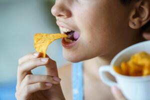 Anonymous girl about to eat yummy nacho chip at home photo