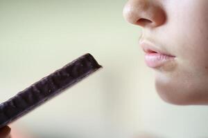 Crop unrecognizable girl with protein bar at home photo